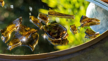 Mirror on the floor covered with dark glass fragments and glimpse of part of the terrestrial globe
