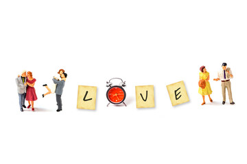 miniature couple with inspiration motivate idea with text "LOVE" on grunge paper with old retro clock isolated on white background