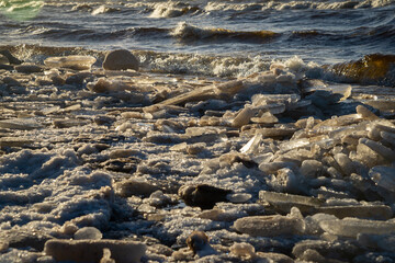 frozen sea side beach panorama in winter with lots of ice and snow in late evening