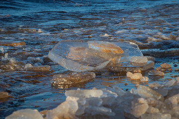 frozen sea side beach panorama in winter with lots of ice and snow in late evening