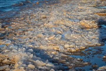 frozen sea side beach panorama in winter with lots of ice and snow in late evening