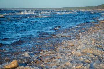 frozen sea side beach panorama in winter with lots of ice and snow in late evening