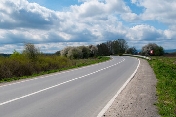 Obraz premium highways in the mountains against the background of the sunny sky and the white clouds