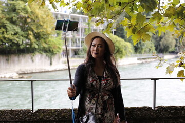 Une très belle femme asiatique fait un selfie sur un pont à Baden