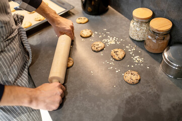 Top view of male hands rolling out raw biscuits