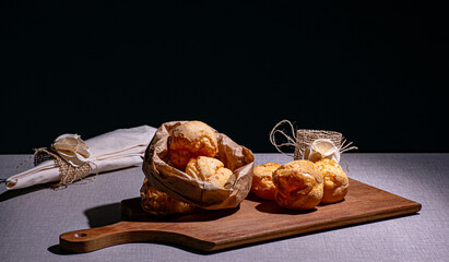 delicioso lanche com pão de queijo que está sobre uma madeira e acompanha um guardanapo