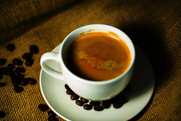 Cup of coffee with coffee beans on coffee sack
