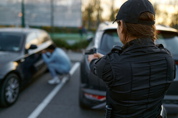 Policewoman aiming gun at car thief backview
