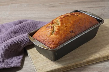 Peel and stick wall murals Bread Freshly baked banana bread in baking tin on wooden board
