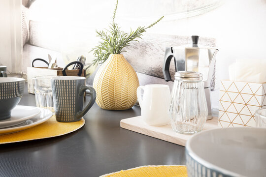Gray countertop on which there is a breakfast service and coffee maker