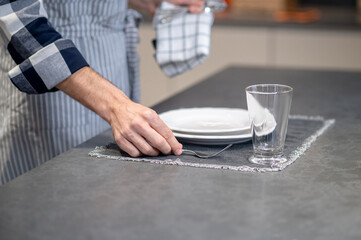 Fototapeta na wymiar Male hand putting fork on napkin near plate