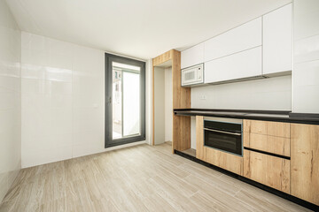 Large semi-furnished kitchen with chestnut root cabinets combined with white and black aluminum door with stoneware floors