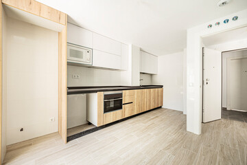 Large semi-furnished kitchen with chestnut root cabinets combined with white and black aluminum...