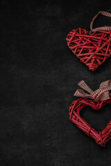 Moscow, Russia, January 2022 Valentine's Day card, two hearts woven from red straw on a dark background
