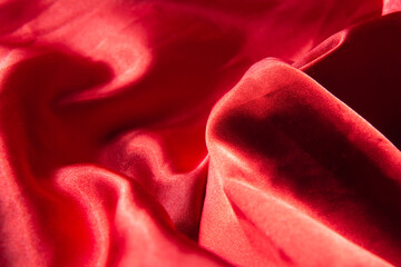 Beautiful red silk background. Draped background of fabric, texture. Copy space. Close up