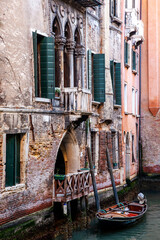 A boat anchored in front of  an entrance of a building in canal at Venice, Italy.