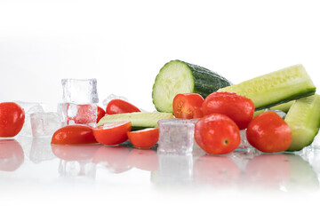 cucumber, tomatoes on a white background with ice cubes and crushed ice
