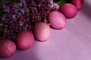 Close-up of beautiful lilac Easter eggs with blooming lilac branches. Easter decor. Selective focus.