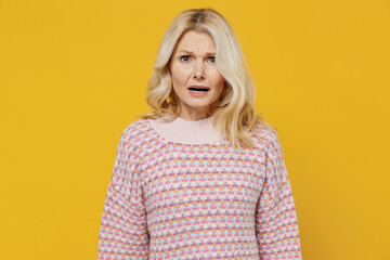 Elderly disappointed displeased dissatisfied sad blonde caucasian woman 50s wearing pink sweater...