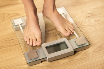 Female feet on the modern digital weighing scale