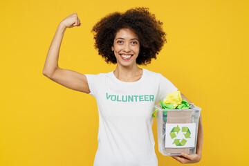 Young fun woman of African American ethnicity wear white volunteer t-shirt hold waste sorting boxes...
