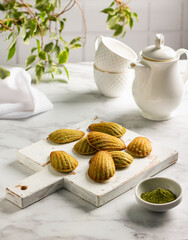 Homemade traditional french madeleine cookies with matcha tea, sweet dessert and tea on the table. menu concept