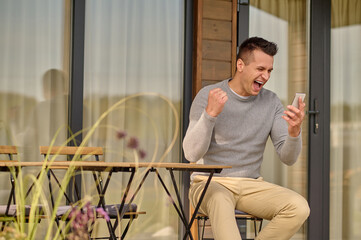 Man with open mouth looking at smartphone