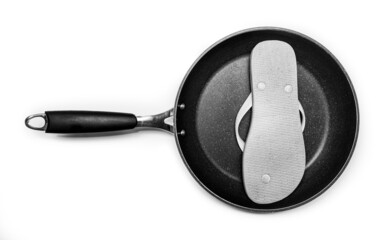 Sartén de cocina con una chancla de playa. Fotografía conceptual en blanco y negro.