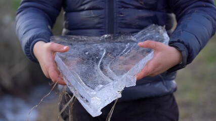 7 year old boy holds two sheets of ice that are melting in the sun - global earth warming and climate change © andrea