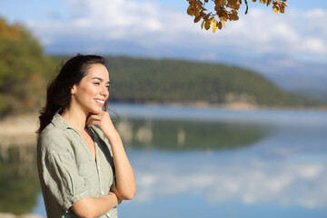 Happy woman contemplating views in a lake