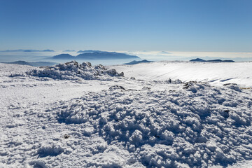 Fototapeta na wymiar mountains of the Apennines immersed in the mist seen from the Matese mountains with snow. Monte Mutria, Matese National Park, Campania and Molise, Italy