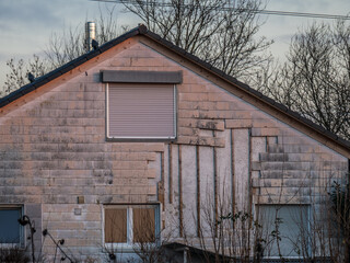 Altes Wohnhaus mit beschädigter Wandverkleidung aus Asbest