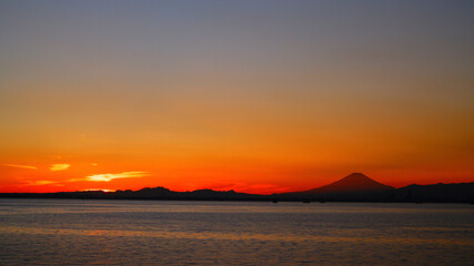 海上からの夕日と富士山のシルエット