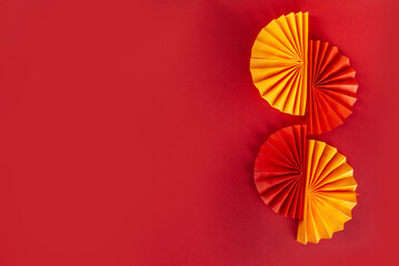 Chinese new year background. Red and golden yellow flatlay with traditional Chinese new year decor, envelopes with wishes, gold coins, fans, Chinese lanterns, oranges and tea