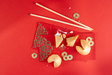 Chinese new year background. Red and golden yellow flatlay with traditional Chinese new year decor, envelopes with wishes, gold coins, fans, Chinese lanterns, oranges and tea