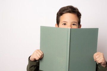 Close up portrait student boy with green notebook isolated over white background.