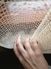 Woman's hand touches the curtain on the window
