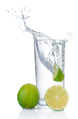Pure water splashing out of glass and fresh limes on white background