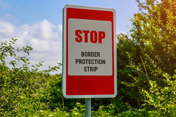 The inscription or text in English STOP BORDER PROTECTION STRIP. Warning post about the state...