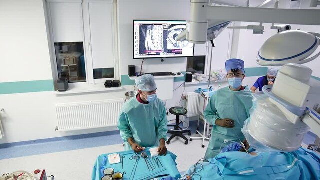 Man surgeon performing operation in innovative operating theater. Top view on the doctors at work.
