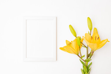 Mockup with a white frame and yellow lilies on a light background