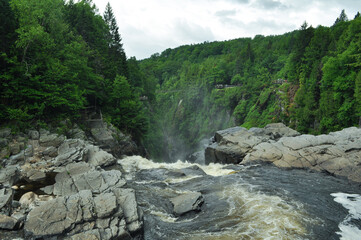 Above the waterfalls cliff edge with water falling between rocks during spring