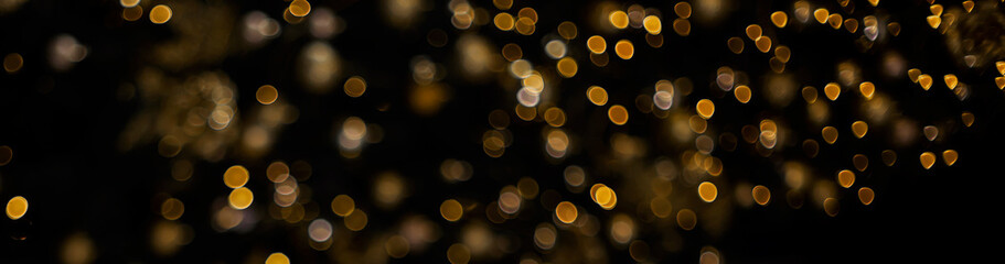 Golden yellow orange bokeh of christmas lights on black isolated background 