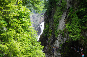 Waterfall in the forest crashing down between the rocks people rock climbing