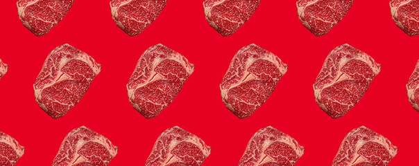 Pattern made of raw meat beef marbled prime cut steak Ribeye on red clean background from above, minimalist beefsteak concept 