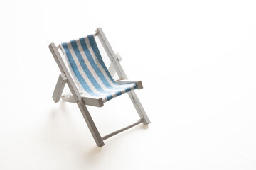 Deck chair, white blue striped beach chair isolated on white background.