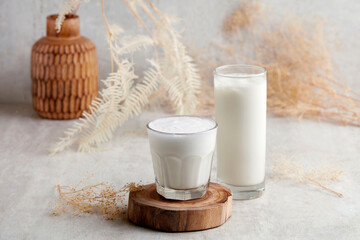 Two Glass jar of babyccino drink with whipped milk or cream. Isolated on wood. Drink for babies