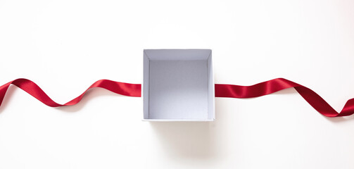 Valentine day gift, open white box and red satin ribbon isolated on white, empty space.