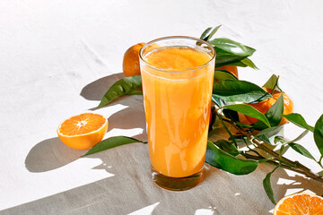 Ripe bio oranges and a glass of fresh squeezed orange juice on white background. Organic Sicilian...