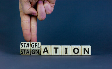 Stagflation or stagnation symbol. Businessman turns cubes, changes the word stagnation to...